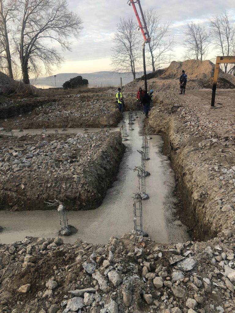 Alapárok kibetonozott sávja a sziklás altalajban, háttérben az autódaru, Balatonboglár