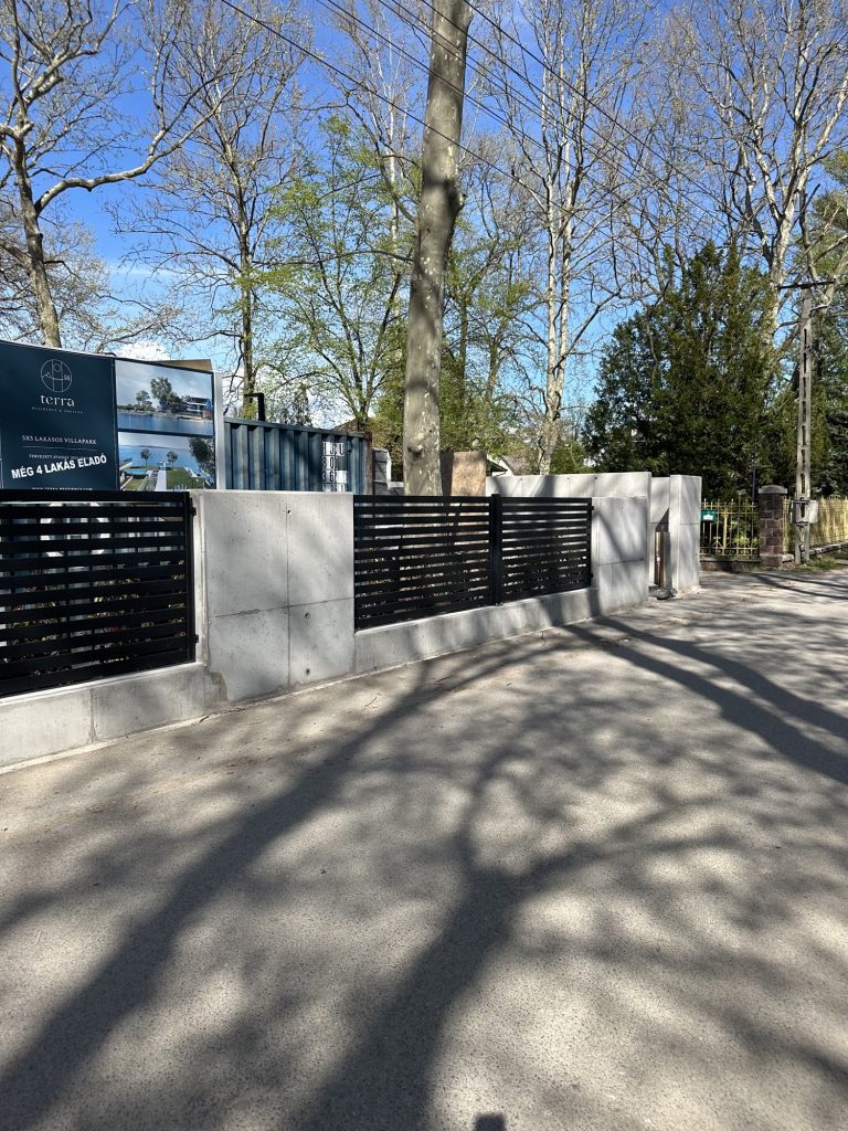 Látszóbeton kerítés a Terra villapark projekttáblájával, Balatonboglár