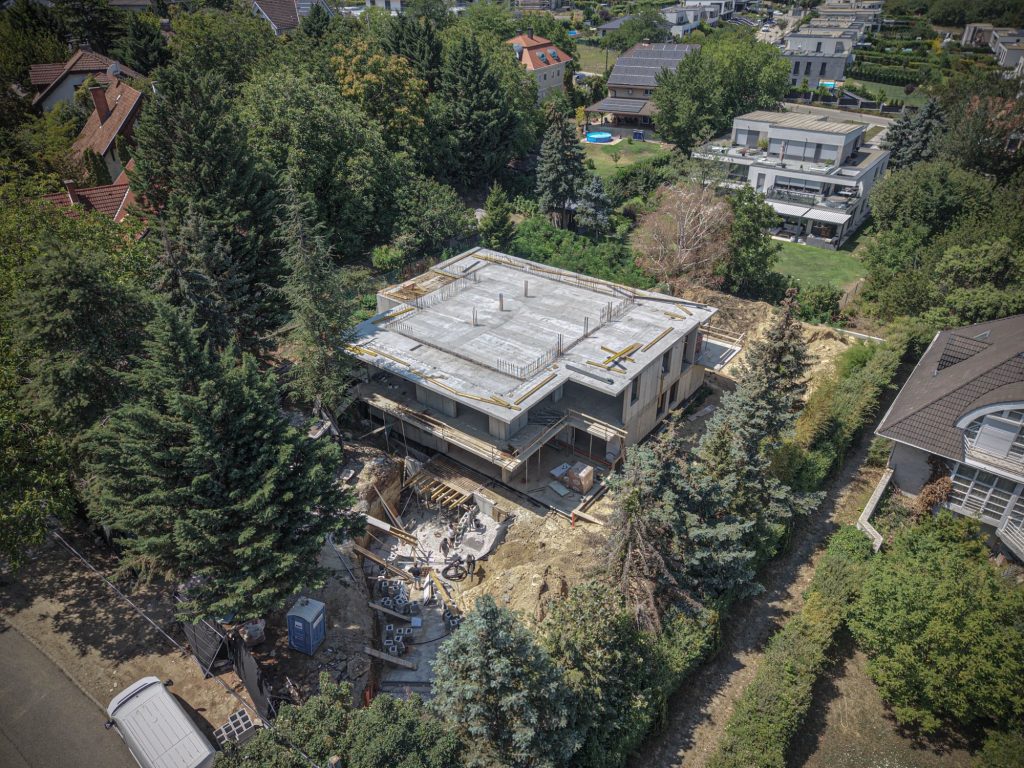 Az épülő szerkezet a fákkal határolt óbudai telken, magasabb nézőpontból, Testvérhegyi utca